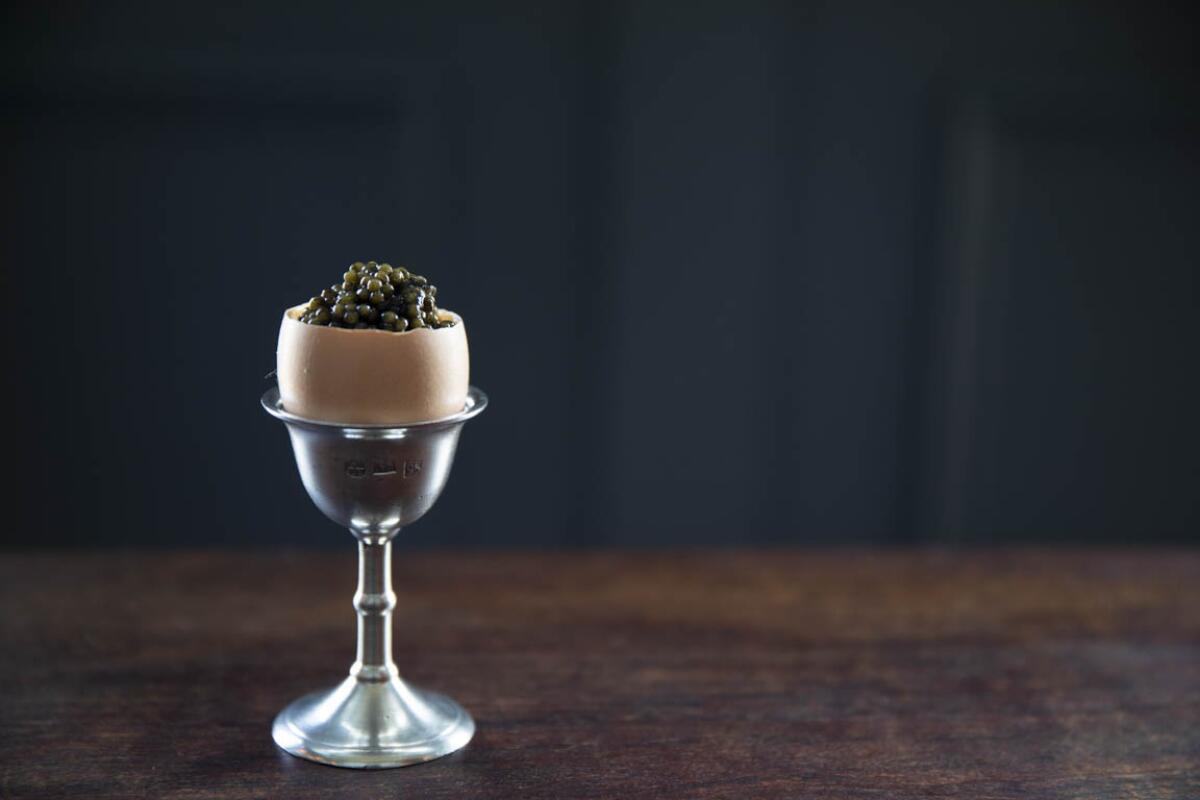 An egg filled with caviar in an egg glass 