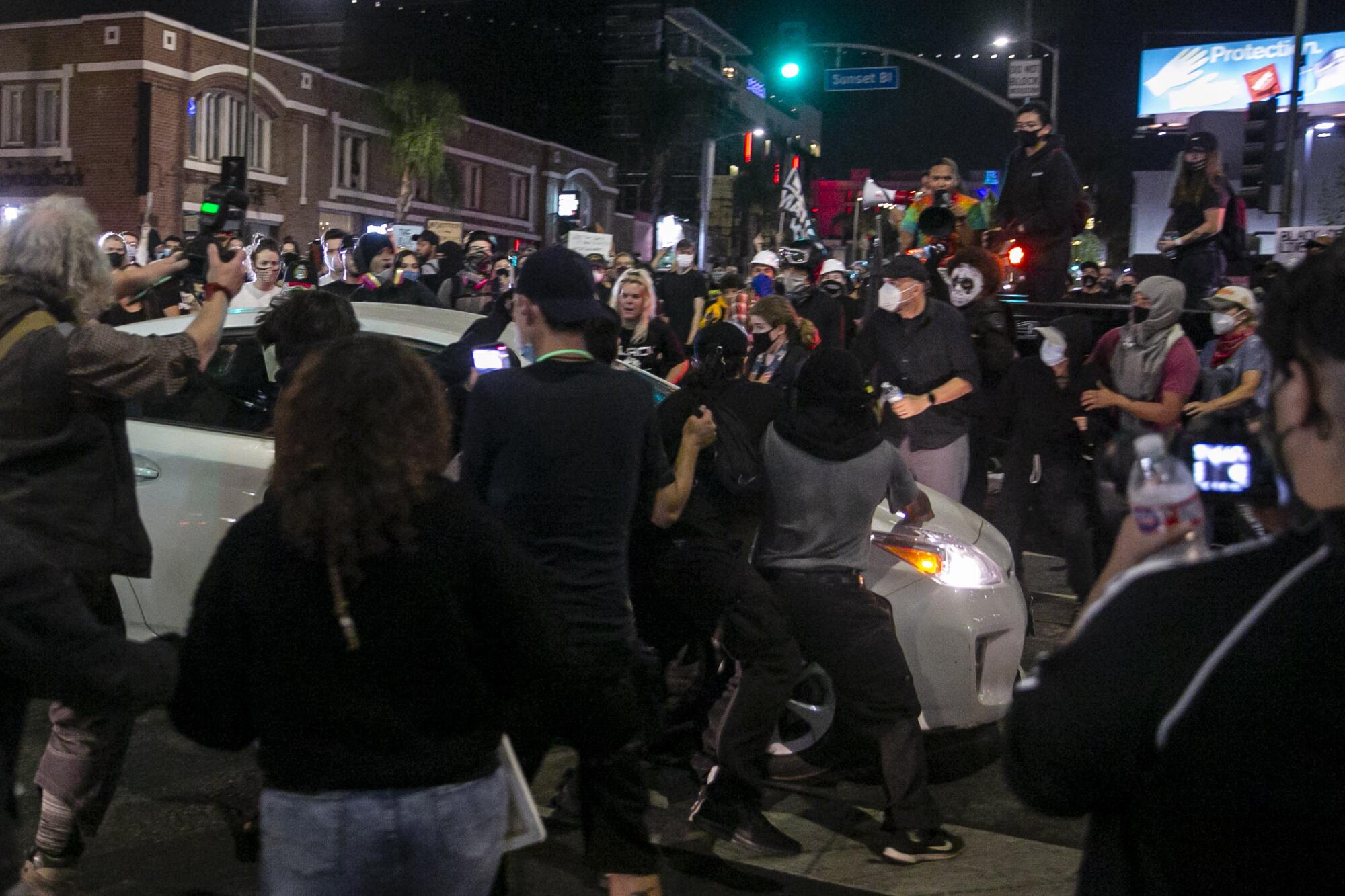 A Prius runs through a crowd of people on Sunset Boulevard during a protest held for Breonna Taylor in Hollywood