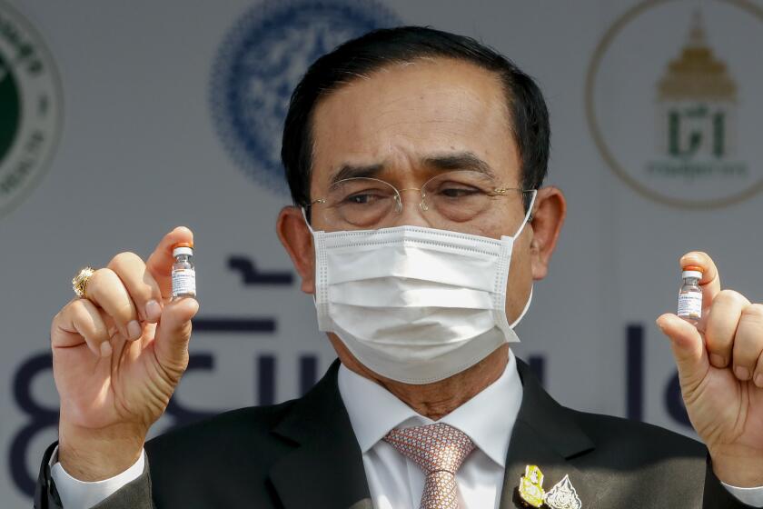 FILE - In this Feb. 24, 2021, file photo, Thai Prime Minister Prayuth Chan-ocha holds samples of Sinovac vaccine during a ceremony to mark the arrival of 200,000 doses of the Sinovac vaccine shipment at Suvarnabhumi airport in Bangkok, Thailand. Prayuth was not particularly lauded for his leadership last year against the coronavirus, but for much of 2020 Thailand fought the disease to a standstill, with low infection and death rates envied by more developed countries. (AP Photo/Sakchai Lalit, File)