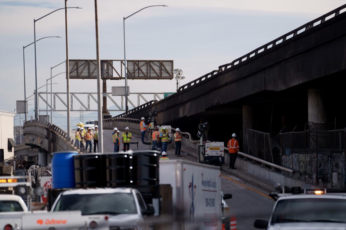 Crews examine damage at the site of a fire under Interstate 10 in Los Angeles.