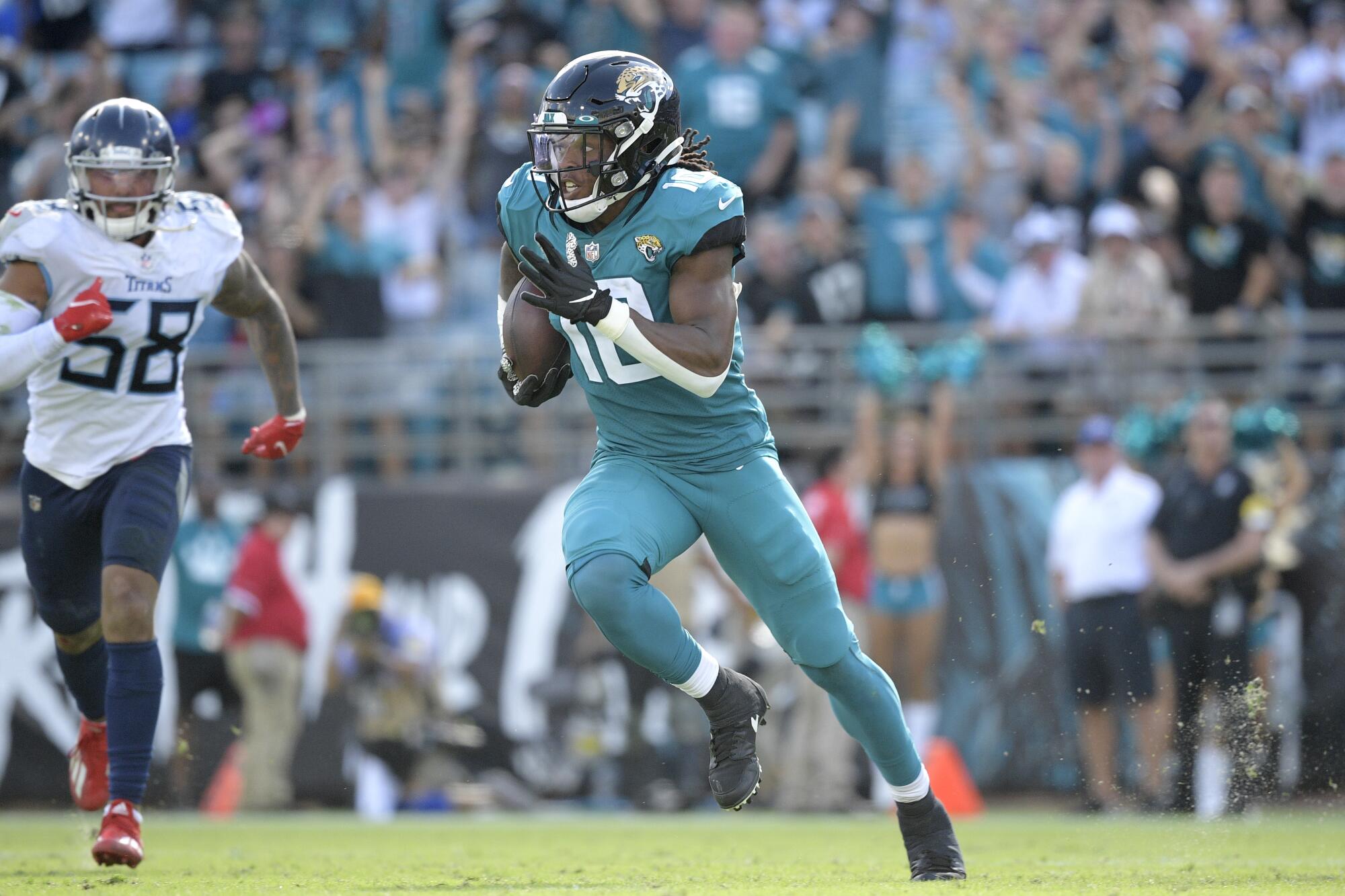 Jacksonville Jaguars wide receiver Laviska Shenault Jr. runs in front of Tennessee Titans outside linebacker Harold Landry.