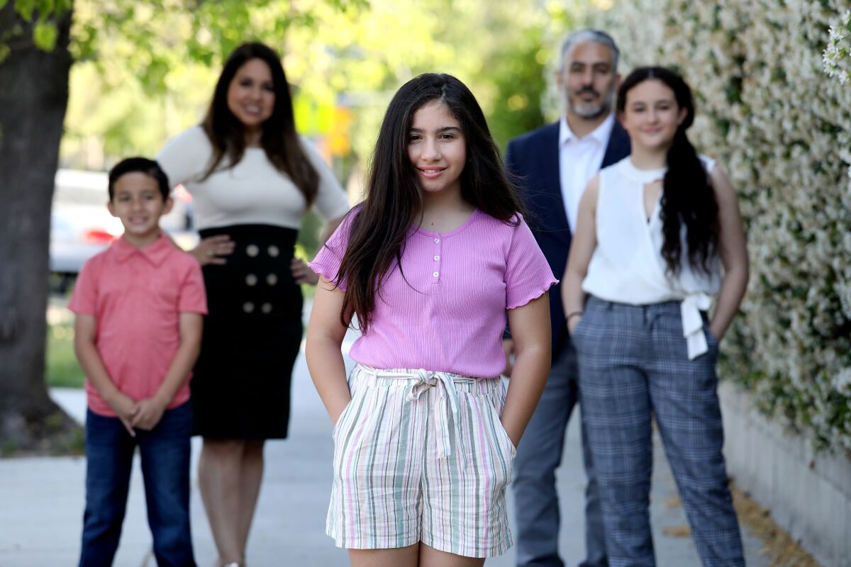A girl with her parents, brother and sister.