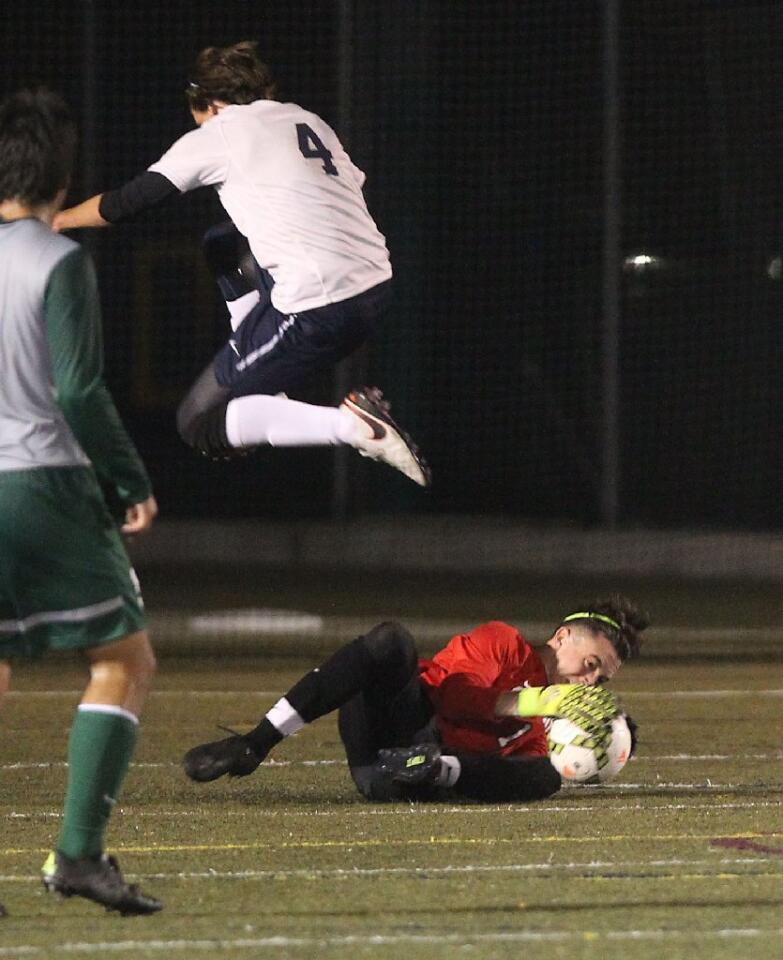 Sage Hill School goalie Chase Rebeil stops a shot against a charging Ethan Crnic of St. Margaret's.