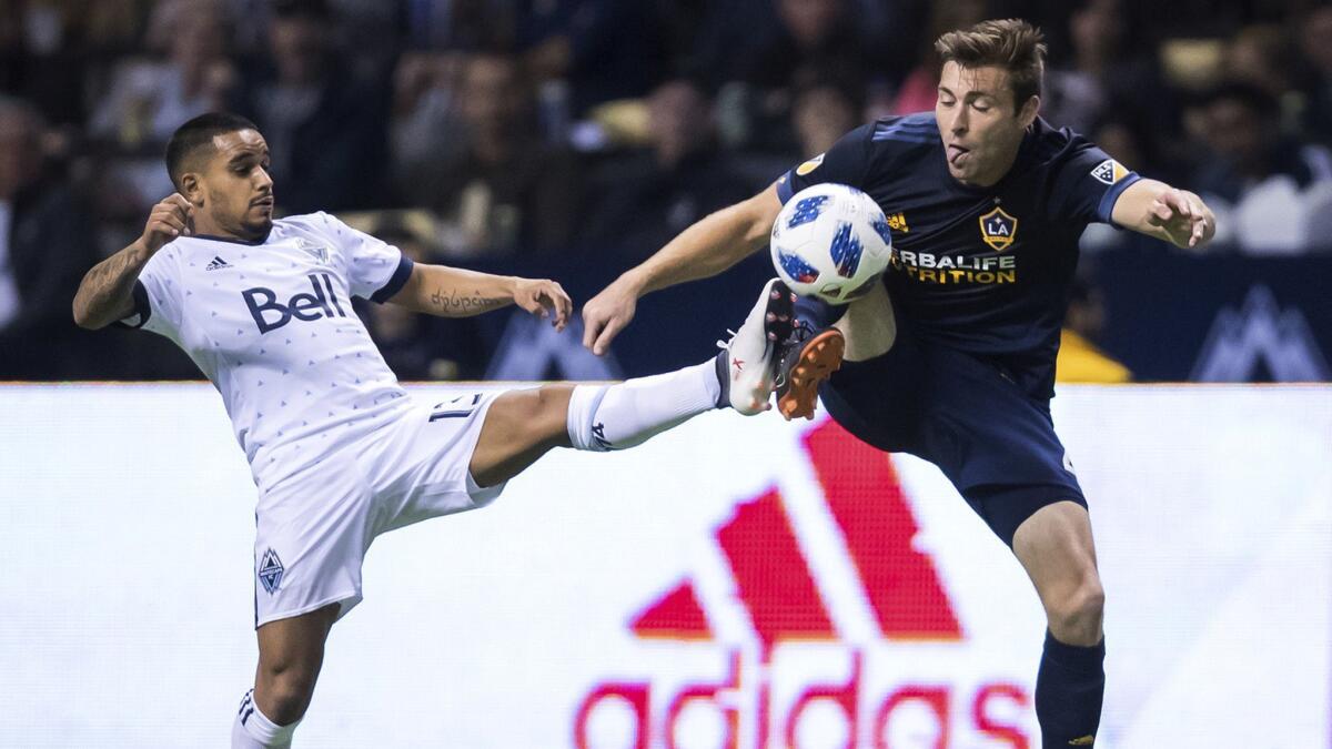 Vancouver's Cristian Techera, left, and the Galaxy's Dave Romney vie for the ball during the second half of a game March 24.