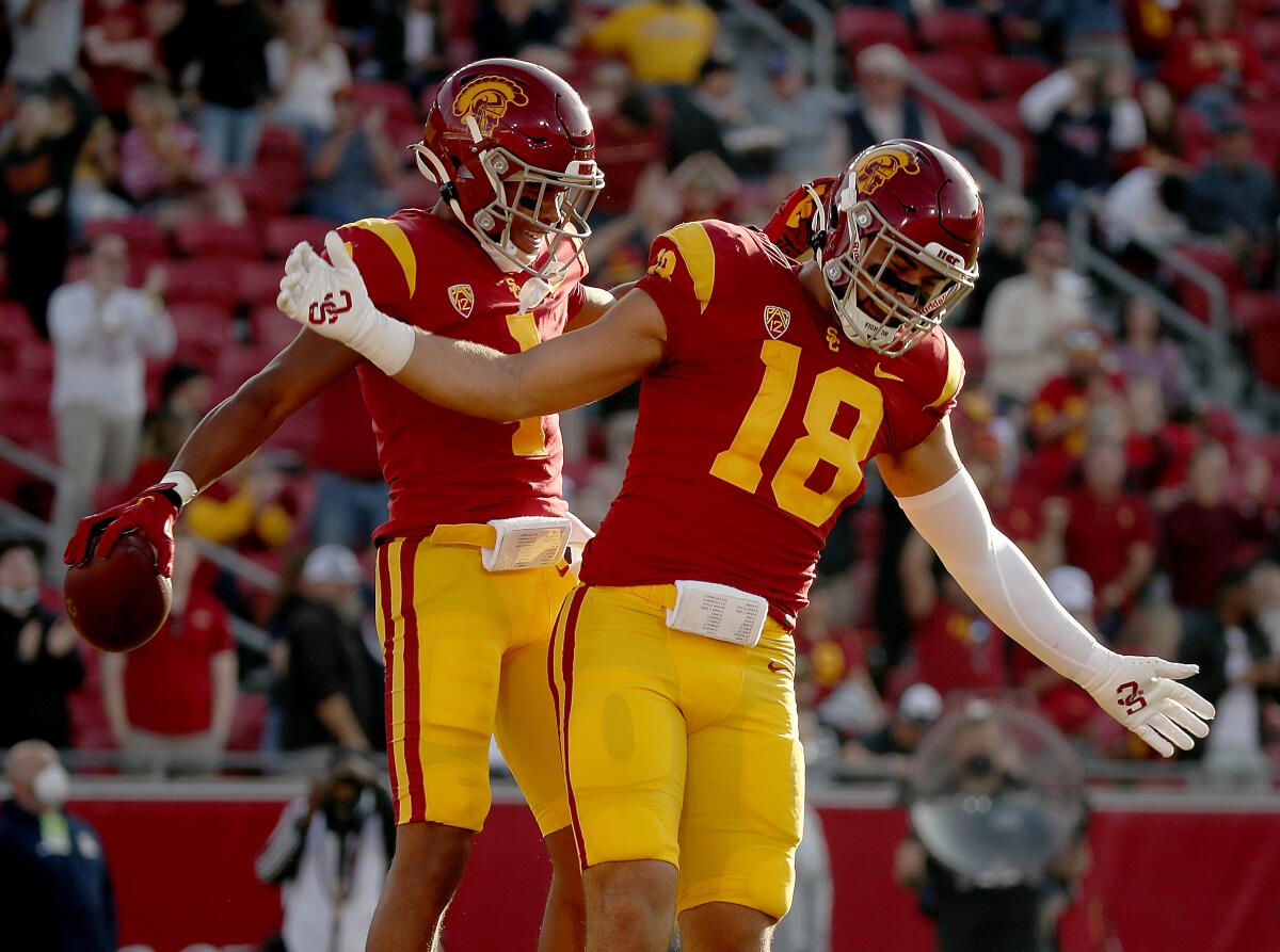 Trojans wide receiver Gary Bryant, left, celebrates with teammate Jude Wolfe after making a 62-yard touchdown catch.