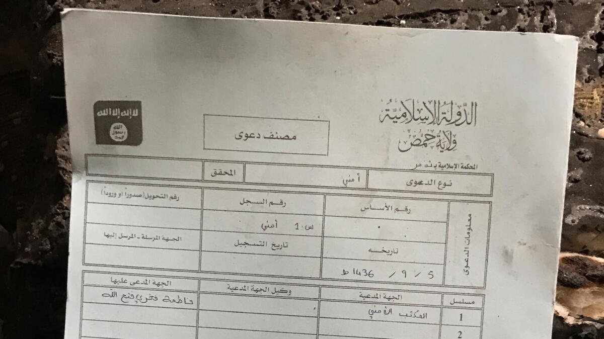 A document left in the sharia court in Palmyra sentences Fatima Fakri Fathallah to death by stoning. Islamic State's black-and-white emblem, seen on its flag, appears on the upper left.