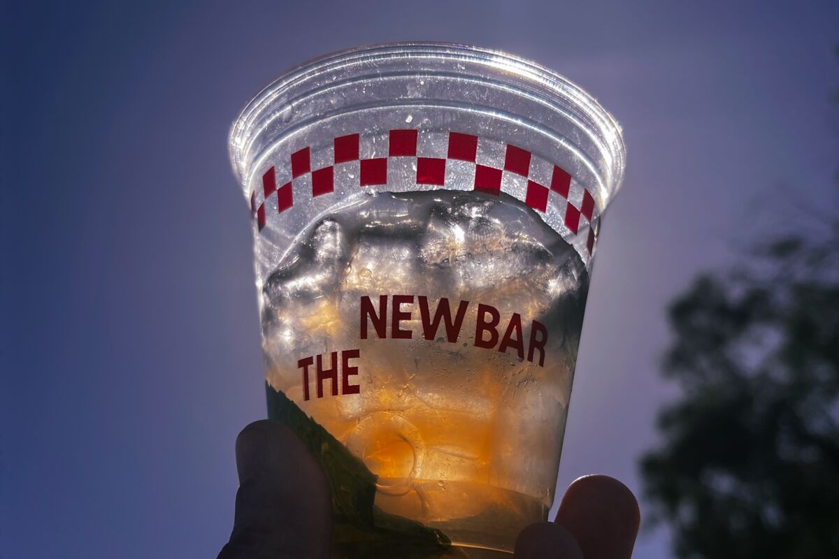 A hand holding a mocktail from The New Bar