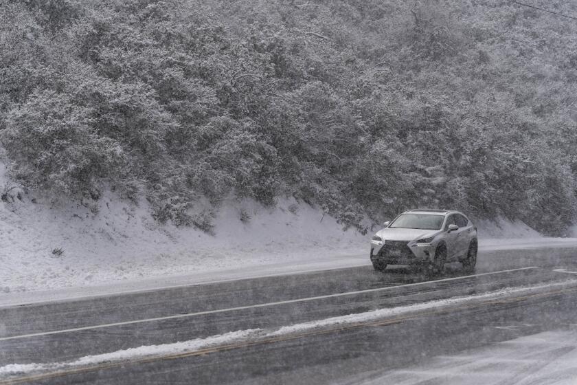 Un automovilista conduce sobre una carretera nevada en el Bosque Nacional Angeles cerca de La Canada Flintridge, California, el jueves 23 de febrero de 2023. (AP Foto/Jae C. Hong)