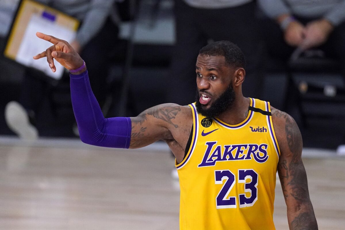Los Angeles Lakers' LeBron James talks to his teammates during the second half of an NBA conference.