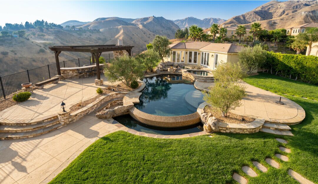 The pool surrounded by patios and a panoramic view of hills.