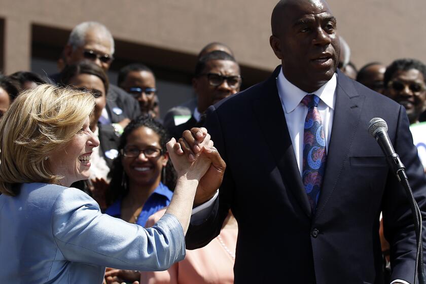 Former Lakers great and current Dodgers executive Magic Johnson gives Wendy Greuel a high-five after endorsing her campaign to be mayor of Los Angeles.