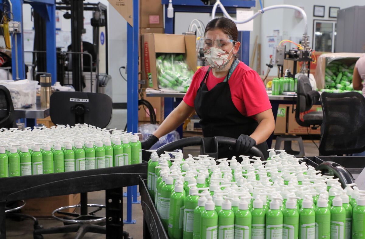 An employee at Dr. Bronner's, a Top Workplace winner in previous surveys, with carts of the company's body lotion. 
