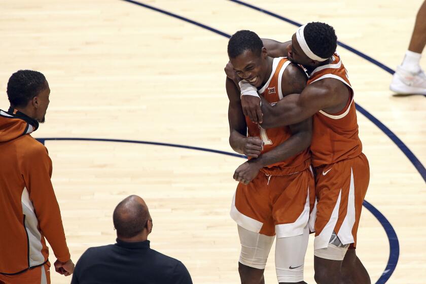 Texas guards Andrew Jones (1) and Courtney Ramey (3) celebrate after Jones scored against West Virginia during the second half of an NCAA college basketball game Saturday, Jan. 9, 2021, in Morgantown, W.Va. (AP Photo/Kathleen Batten)