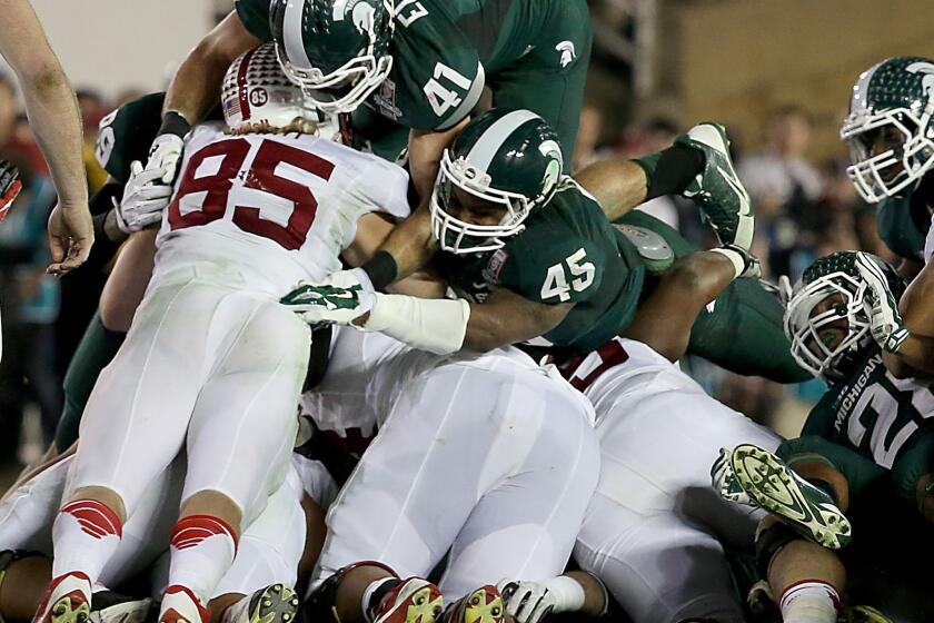 Stanford fullback Ryan Hewitt (85) is stopped short of a first down by Michigan State linebackers Kyler Elsworth (41) and Darien Harris (45) on a key fourth-quarter play that helped the Spartans seal a 24-20 victory in the 100th Rose Bowl game on Wednesday in Pasadena.