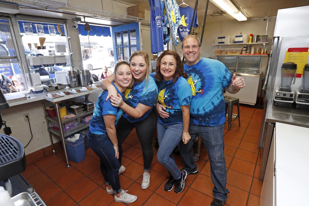 Sugar 'n Spice owners Courtney and Will Alovis, right, pose with employees Fiona and Eilish Zachary as the business celebrates 75 years on Balboa Island in Newport Beach.