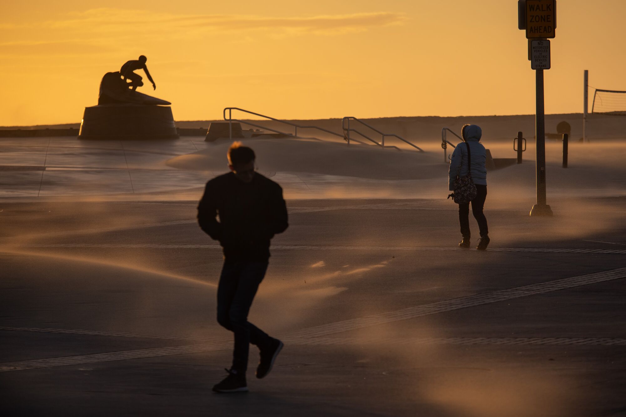 High winds blow sand inland pelting walkers and forming piles along Pier Plaza, in Hermosa Beach, Wednesday.