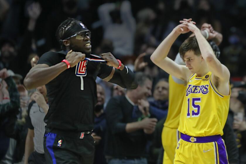 Los Angeles, CA - February 03: Clippers point guard Reggie Jackson, left, celebrates his winning basket as Lakers forward Anthony Davis, background is dejected after missing his final shot along with guard Austin Reaves, #15 in the final seconds at Crypto.com Arena on Thursday, Feb. 3, 2022 in Los Angeles, CA. Clippers on 110-111. (Allen J. Schaben / Los Angeles Times)