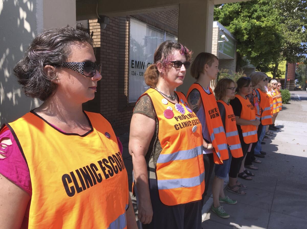 Escort volunteers line up outside the EMW Women's Surgical Center in Louisville, Ky.