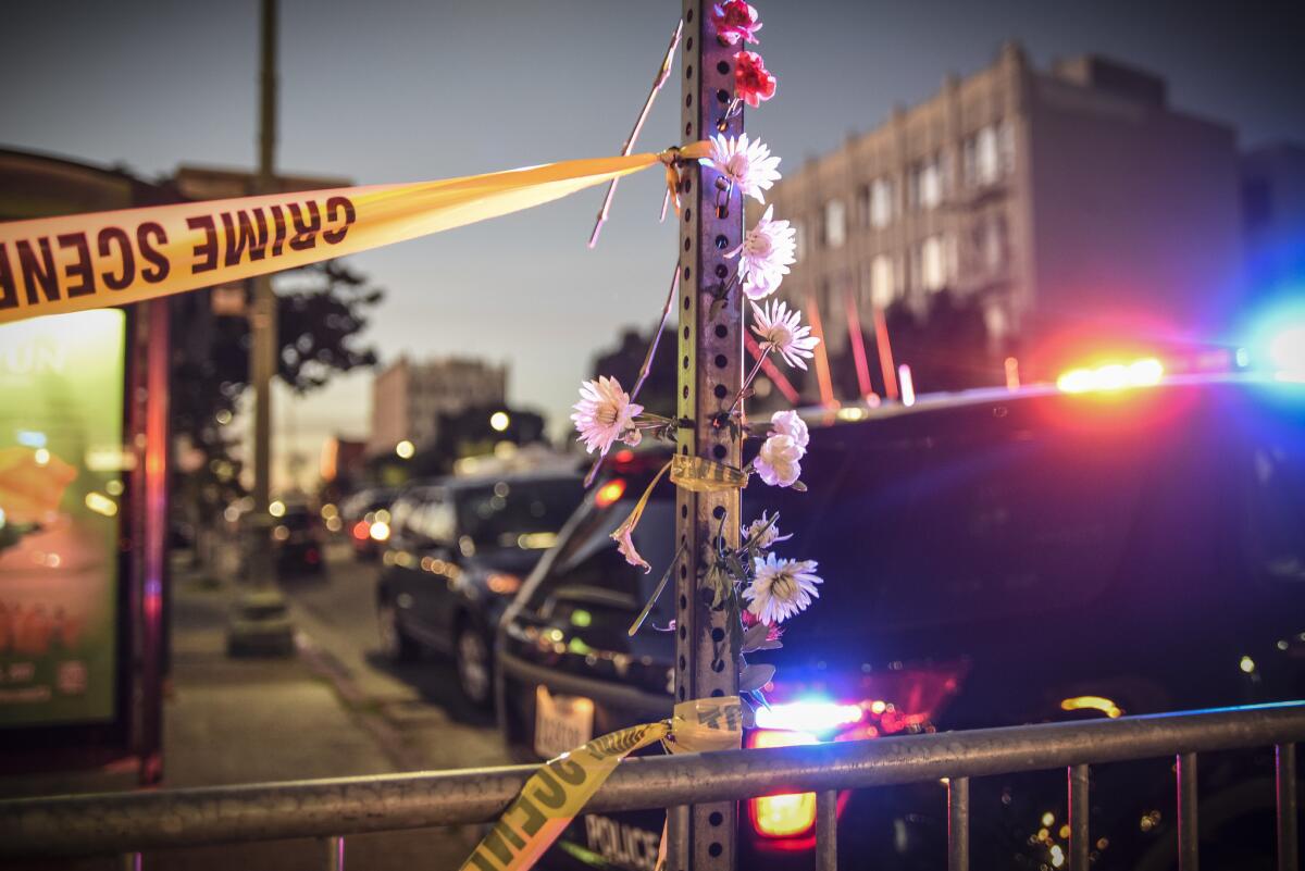 Flowers are left near an Oakland warehouse where a fire broke out during a concert, killing 36 people.