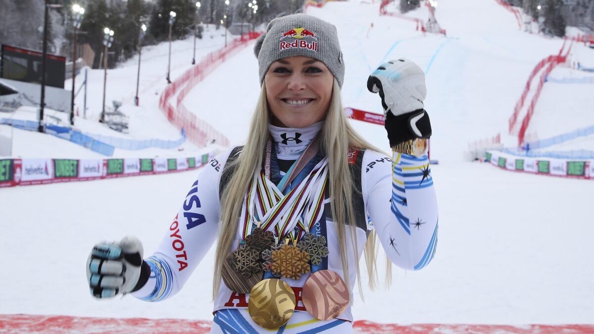 Lindsey Vonn poses with major medals she won during her career after Sunday's downhill race at the world championships on Sunday.