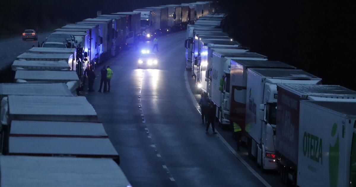Trucks backed up and parked on the highway in southern England while the Channel Tunnel to France remains closed.
