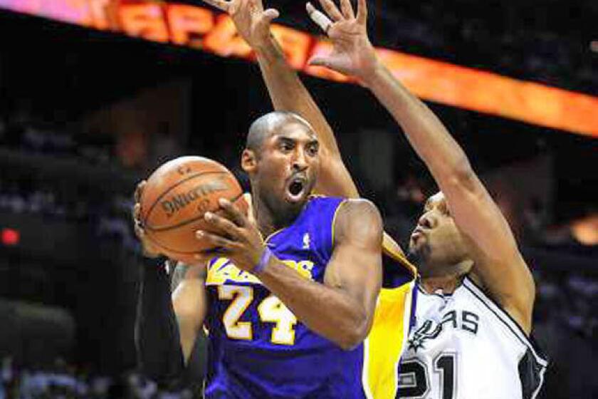 Kobe Bryant looks to pass while being defended by Tim Duncan during a 2008 Lakers-Spurs game.