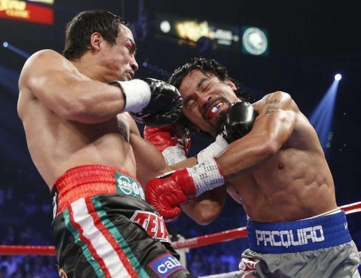 Manny Pacquiao and Juan Manuel Marquez exchange blows in their fight Saturday.