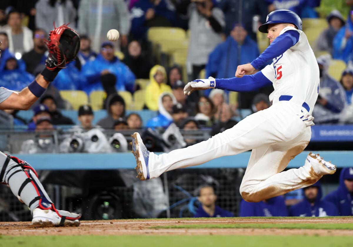 Dodgers baserunner Freddie Freeman goes into a slide before he is tagged out by Cardinals catcher Ivan Herrera.