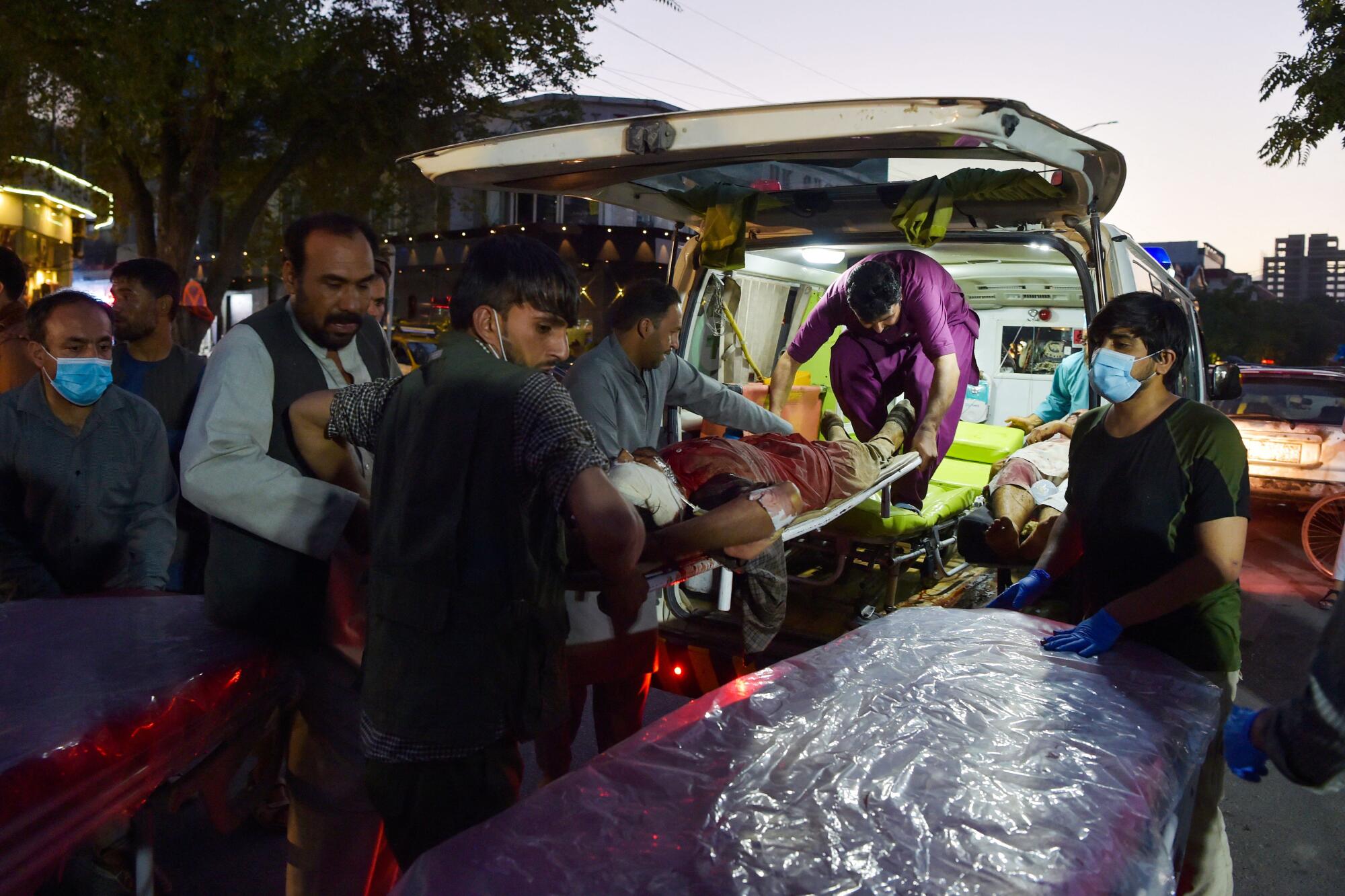 Volunteers and medical staff bring an injured man for treatment 