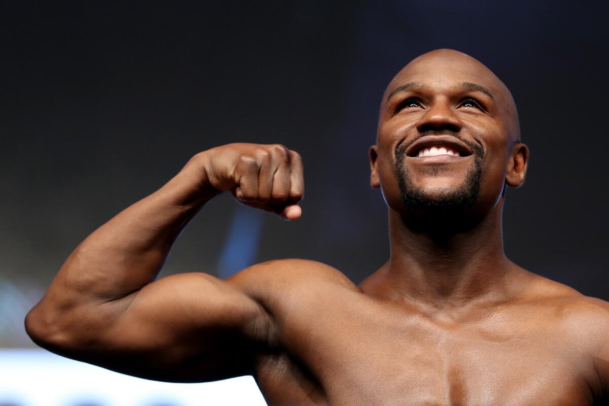 Boxer Floyd Mayweather Jr. poses on the scale during his official weigh-in at T-Mobile Arena on August 25, 2017 in Las Vegas, Nevada. Mayweather will meet UFC lightweight champion Conor McGregor in a super welterweight boxing match at T-Mobile Arena on August 26.