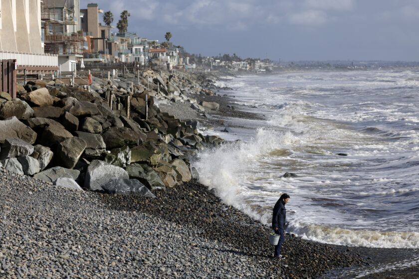 OCEANSIDE, CA - MARCH 23, 2023: A woman stands on rocks at Buccaneer Beach in Oceanside on Thursday, March 23, 2023. (Hayne Palmour IV / For The San Diego Union-Tribune)