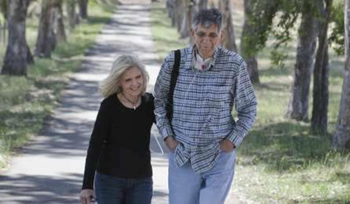 Former USC two-time All-American John Rudometkin walks with his wife, Carolyn, at their Newcastle home in 2010.