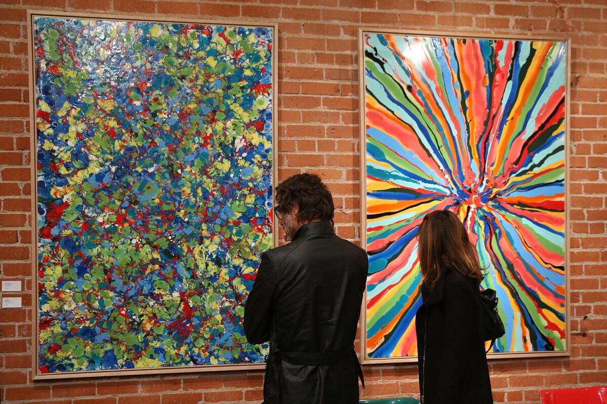 Visitors view works by David Bromley. The Australian artist's pieces are being shown in downtown Los Angeles.