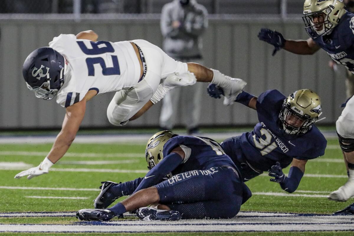 Sierra Canyon running back Anthony Spearman is tripped up by St. John Bosco defenders.
