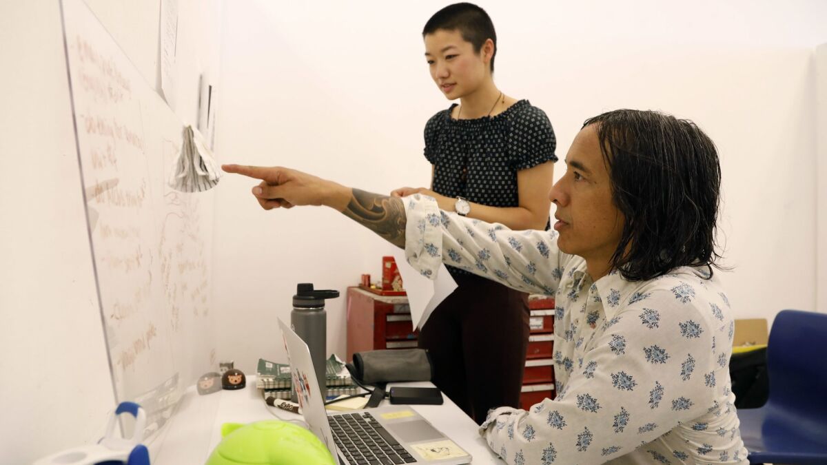 UC Santa Barbara art professor Kip Fulbeck, right, meets with art honors student Yichen Li in her campus studio. UCSB is admitting thousands of Chinese international students but failing to adequately support them, leading to problem behavior, faculty say.