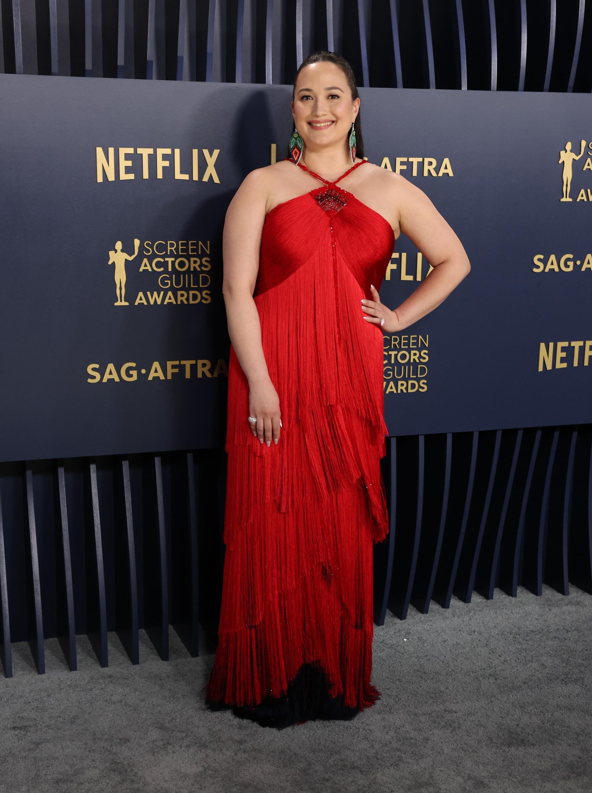 Lily Gladstone wears a red halter dress at the SAG Awards.