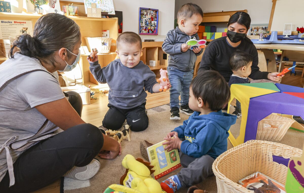 Teachers Lucy Arevalo (left) and Karina Palomino (right) play with children at Miren Algorri's Family Child Care.
