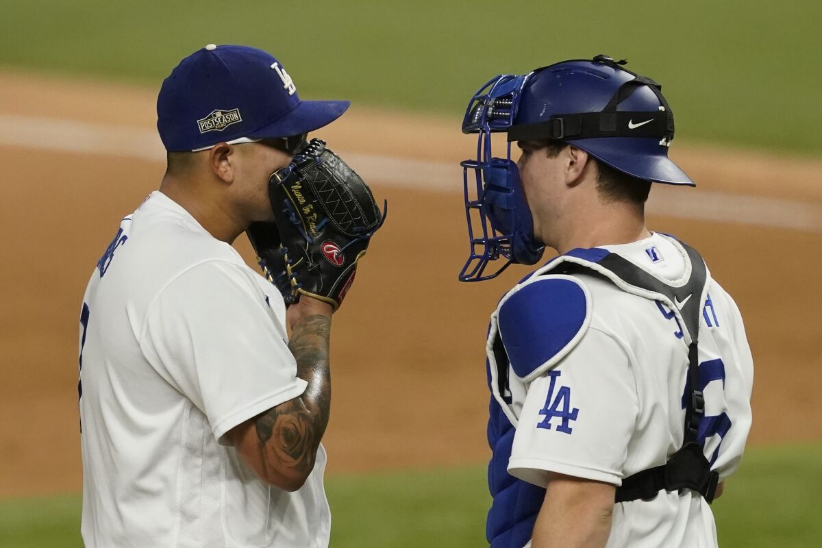 Dodgers pitcher Julio Urías speaks with catcher Will Smith in the seventh inning.