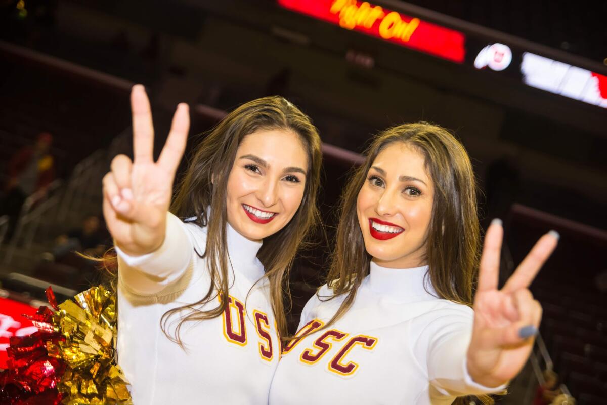 USC Song Girls Bella Robakowski, left, and her sister Adrianna, right, pose for a picture during a Trojans basketball game.