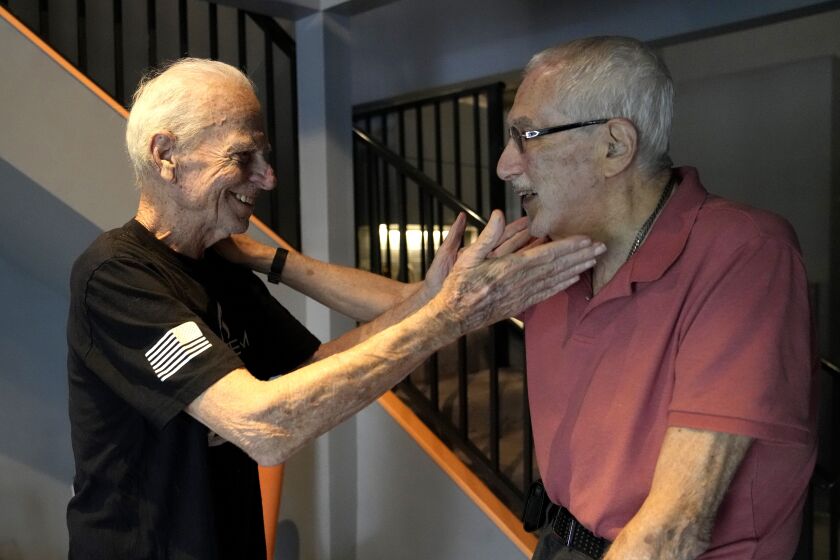 U.S. Army veteran Ed Reichbach, 93, left, greets Vietnam veteran Fred Kalfon, 81, after Kalfon's workout session at the Grey Team veterans center, Wednesday, May 17, 2023, in Boca Raton, Fla. The center is helping veterans with post-traumatic stress disorder and other mental and physical ailments get back into the civilian world. (AP Photo/Lynne Sladky)