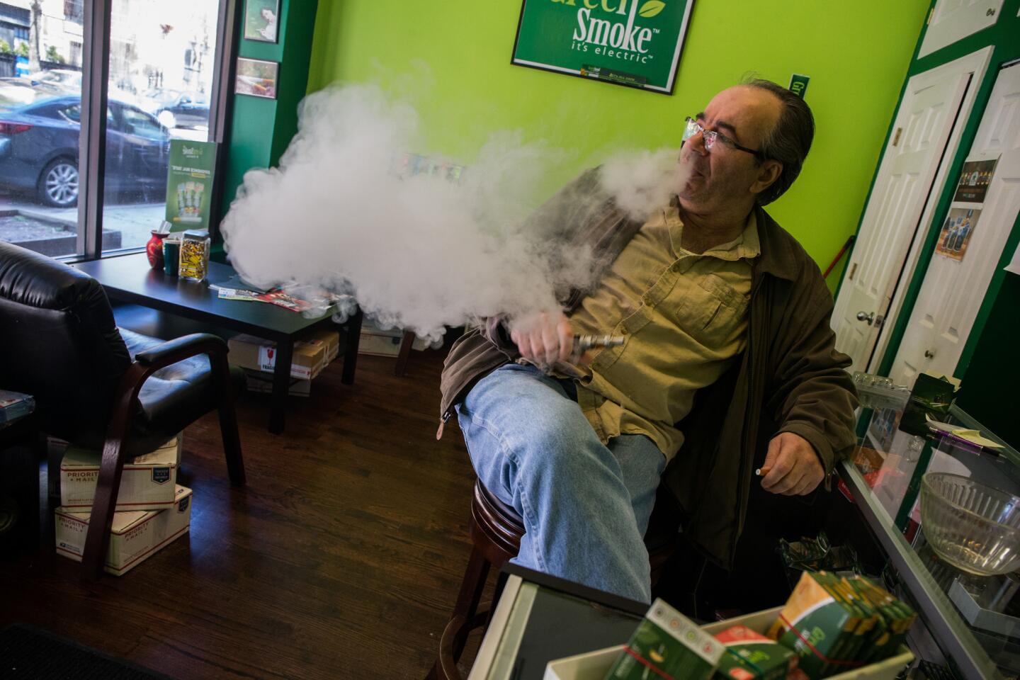 Frank Rex, owner of Let's All Vape, e-cigarette store in Chicago, talks May 5, 2016, about the new regulations. Industry groups say the FDA's new regulations that require all vaping products to be subjected to tests costing $1 million or more will force thousands of small businesses to close.