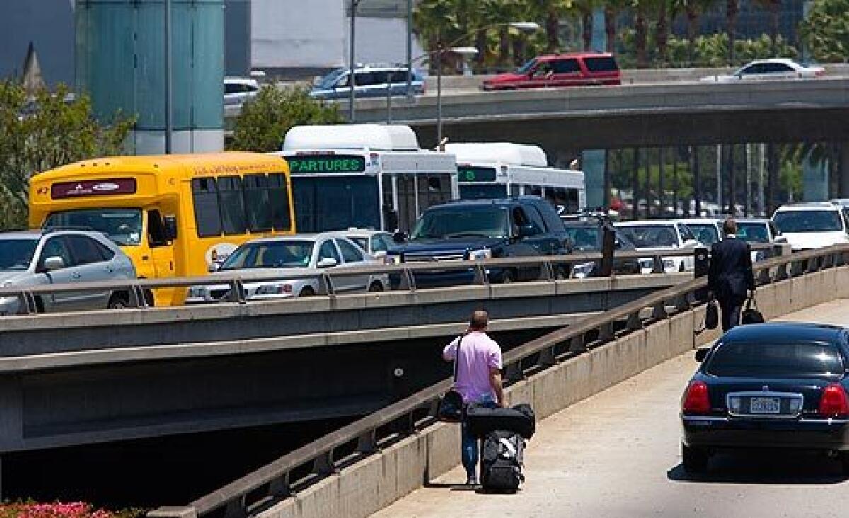 Gridlock forces some travelers to go by foot to and from LAX after a bomb threat today.