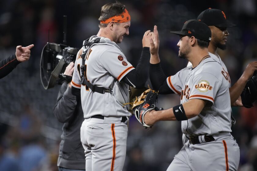 San Francisco Giants catcher Patrick Bailey, left, and right fielder Michael Conforto celebrate the team's win in a baseball game against the Colorado Rockies on Wednesday, June 7, 2023, in Denver. (AP Photo/David Zalubowski)