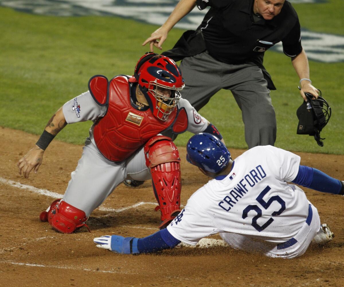 Dodgers left fielder Carl Crawford, right, slides under the tag of Cardinals catcher Yadier Molina to score during the eighth inning of the Dodgers' 3-0 win in Game 3 of the NLCS on Monday.