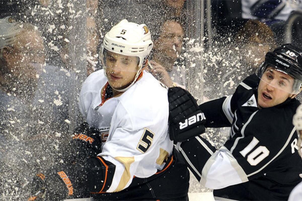 Luca Sbisa of the Ducks gets checked into the boards by Mike Richards of the Kings last December at Staples Center. A game between the two teams scheduled for later this month was among ones canceled by the NHL on Monday.