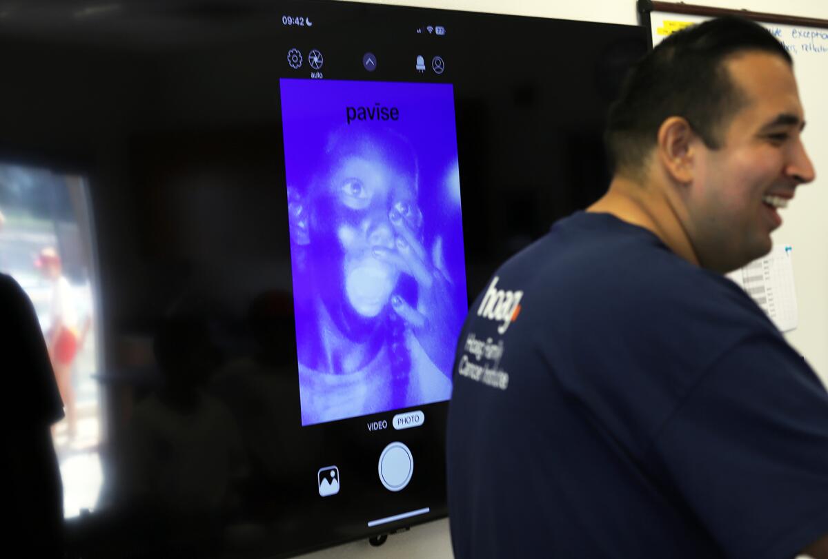 Huntington Beach Junior Lifeguards use an app on their cellphone to help apply sunscreen.