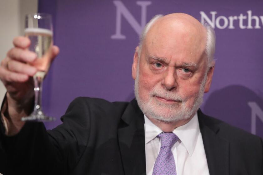 Fraser Stoddart of Northwestern University raises a glass of Champagne at a press conference after winning the 2016 Nobel Prize in Chemistry.