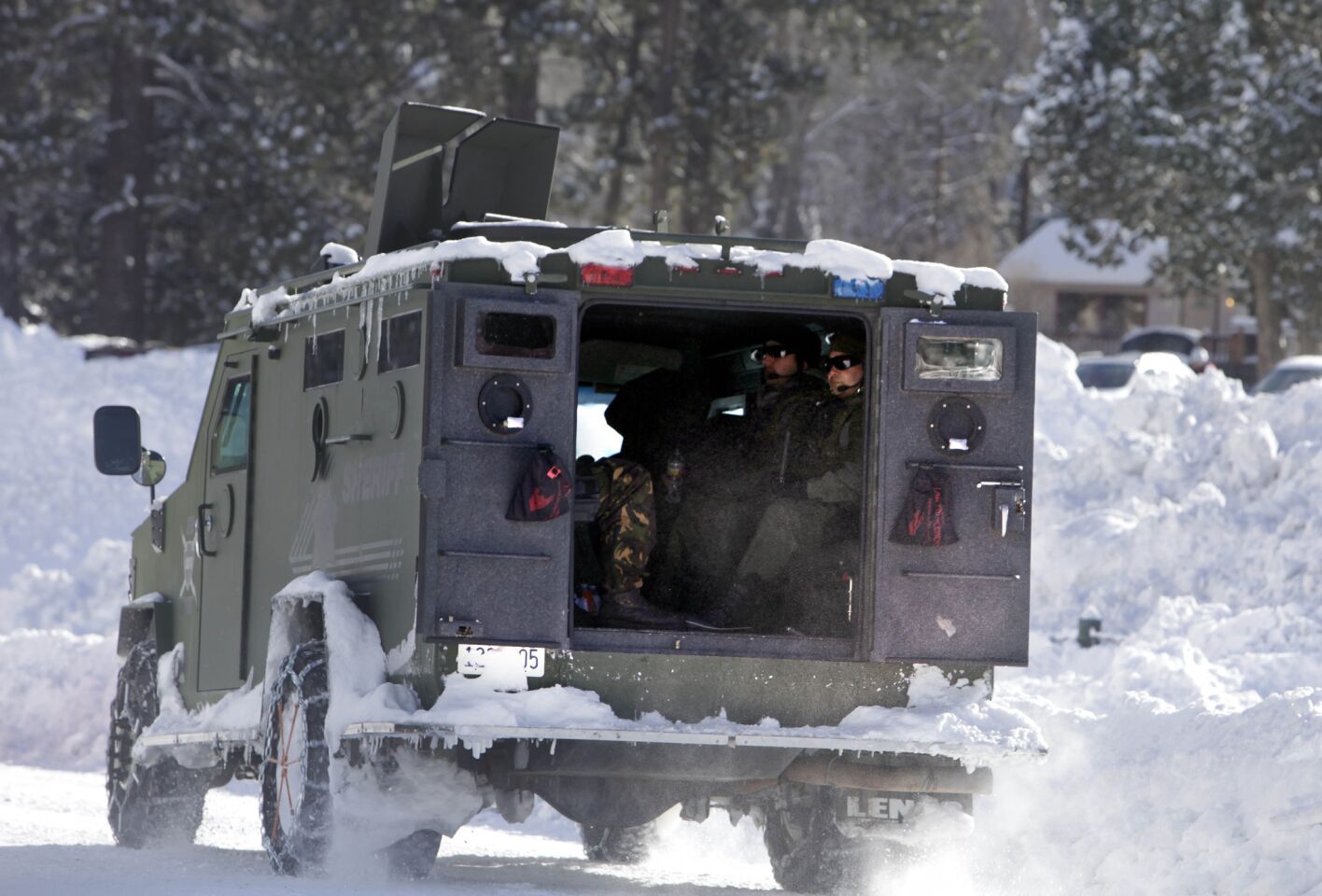 An armored vehicle carrying law enforcement officers rolls down a snow-covered road in Big Bear as the search for Christopher Dorner continued Saturday morning.