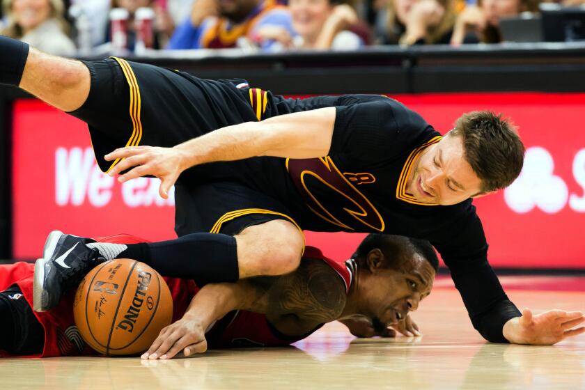 Cleveland guard Matthew Dellavedova lands on top of Trail Blazers guard Damian Lillard while battling for a loose ball during a game Dec. 8, 2015.