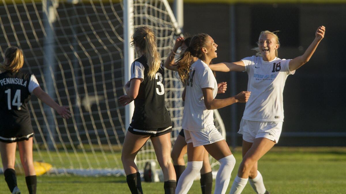 Corona del Mar’s Trinity Rodman, second from right, and teammate Ava McKenzie (18) react after Rodman scores the winning goal during a second overtime against Peninsula in a CIF Southern Section Division 1 first-round playoff game in Newport Beach on Thursday.